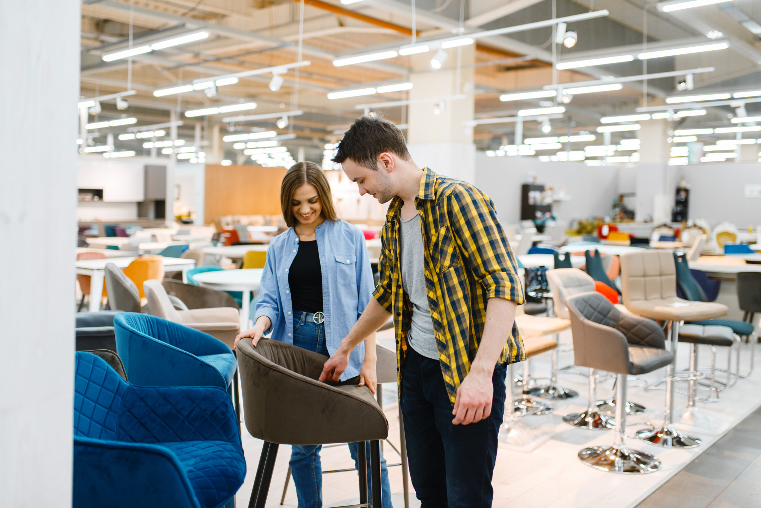 Couple choosing bar chair in furniture store