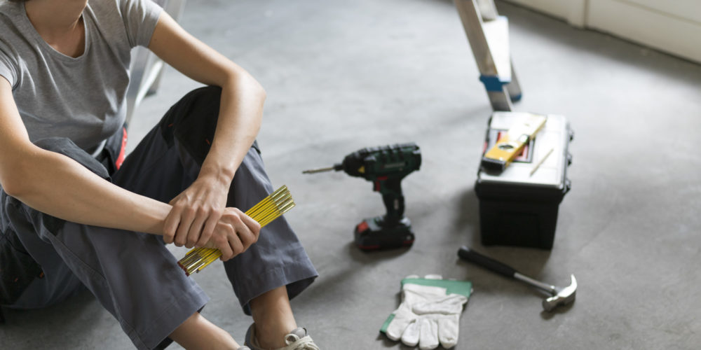 Woman sitting on the floor and planning a home renovation