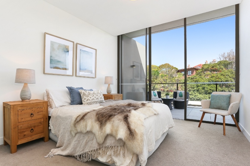 Bedroom with king size bed, styled with decorative cuhionsw and throw